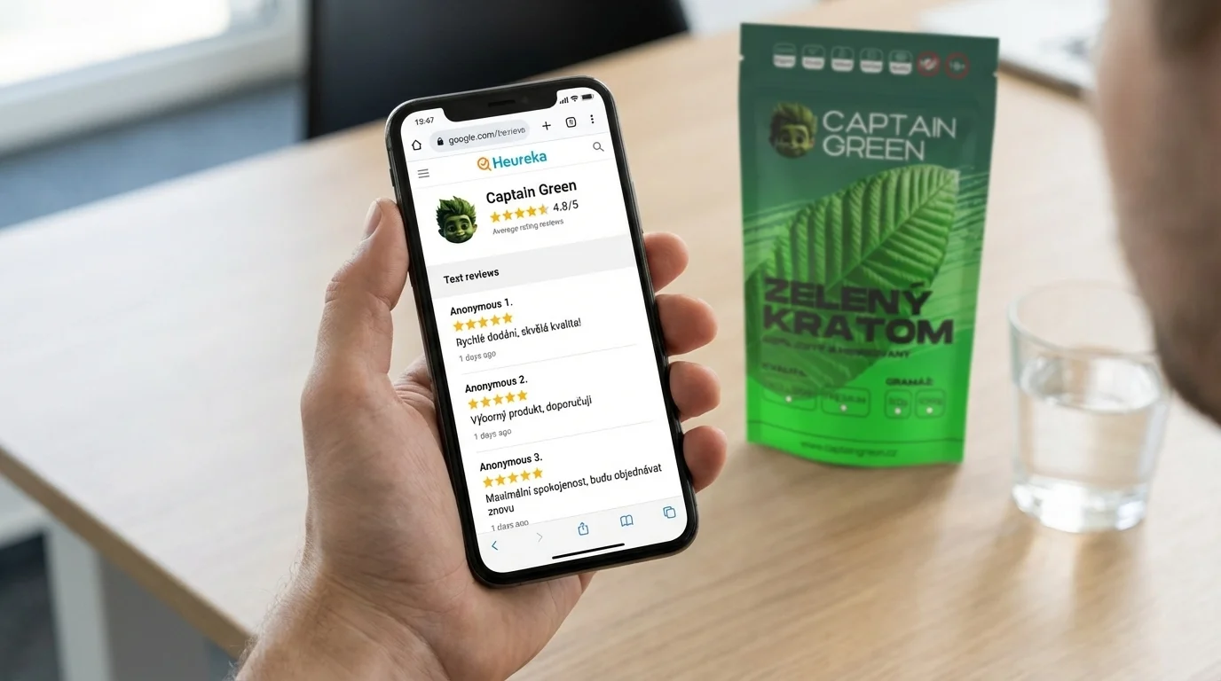 Dospělý uživatel drží mobil s recenzemi e‑shopu Captain Green, v pozadí leží balení kratomu na stole